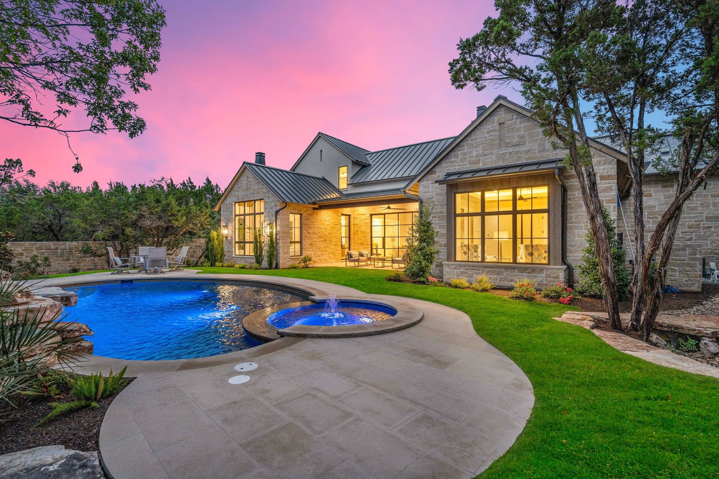 Twilight rear facade, pool, and outdoor living at 4300 Amarra Drive